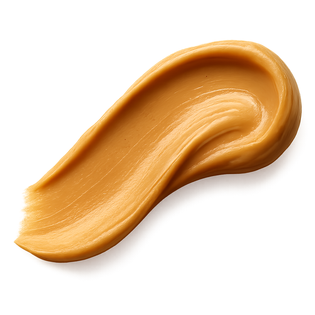 A smooth, appetizing peanut butter swash spread in an elegant curved stroke, rich golden-beige tones, creamy and glossy texture with natural highlights, appearing thick and luscious. The edges of the spread are soft and organic, as if lightly smoothed with a knife. Warm soft lighting to enhance depth and richness. Include a gentle, realistic shadow beneath the swash so it appears resting on the label surface. No background, no plate or surface — transparent PNG, photorealistic detail, premium artisanal food styling, refined and minimal, cozy warm visual mood.make the swash shape slightly dynamic and flowing, like a natural brush stroke facing to the left , visually guiding the eye across the label.