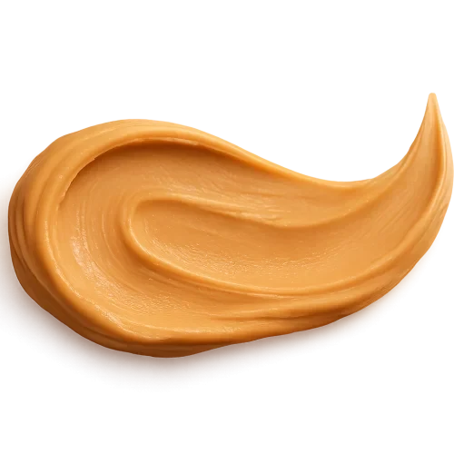 A realistic, appetizing long flowing swash of creamy smooth peanut butter spread in a graceful, painterly stroke. Rich golden-beige tones, velvety texture, natural glossy highlights, and soft subtle ridges from spreading. The shape should be elongated, elegant, and slightly curved, as if gently swept with a single smooth motion. Soft warm studio lighting for a premium, cozy, artisanal look. Include a soft, natural shadow beneath the peanut butter so it appears resting on a label surface. No background, no knife, no plate — transparent PNG. Centered composition, photorealistic detail, high-end food photography style.